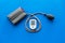 Pulsimeter on the desk of the doctor for diagnostics of cardiac disease on blue background top view