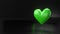 Pulsing green heart shape object on black text space.