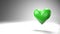 Pulsing green heart shape object on white text space.