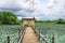 A pump house, small path, pond with full of lotus plants and dramatic sky background