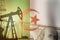 Pump jack, US dollar notes and Algeria flag background. Crude oil and petroleum concept