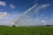 Pump trucks irrigating fields near Homestead, Florida creating rainbow in spray.