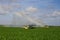 Pump trucks irrigating fields near Homestead, Florida creating rainbow in spray