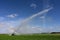 Pump trucks irrigating fields near Homestead, Florida creating rainbow in spray.