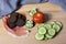 Pumpernickel with cream cheese on a wooden board with tomato, cu