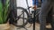 Pumping up bicycle wheel. Bicycle mechanic pumps air into bike tire. Cyclist pumping bicycle wheel with foot pump. Bicycle repairi