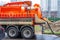 Pumping water from sewage canals during the construction of roads in the city. Truck with orange water tank