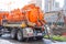 Pumping water from sewage canals during the construction of roads in the city. Truck with orange water tank