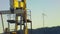 Pumpjack extracting petroleum on an oil well with Wind power plant in background