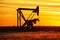 Pumpjack in the oil field at sunset