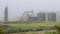 Pumpjack and oil storage tanks shrouded by fog in the State of Oklahoma in the United States of America.