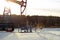 A pumpjack over an oil well in a winter wooded landscape