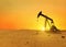 Pumpjack rig pumps oil in the desert at sunset. Dead land and sand, concept. Global warming, creative idea. Resources Energy of