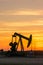 Pumpjack and transmission towers at sunset symbolizing energy transition