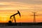 Pumpjack and transmission towers at sunset symbolizing energy transition