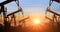 Pumpjacks. Oil pumps silhouette on a sunset sky. Oil and gas production. Oil Industry Pump jack, backlit. Trade, finance and
