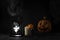 Pumpkin, candles and ghost in a lantern on black background, restless spirit in the fog, halloween concept