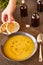 Pumpkin and carrot soup on a brown wooden table. Natural ecological yellow and orange soup puree in a ceramic plate. Healthy meals