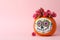 Pumpkin with catrina skull makeup and flowers on pink background