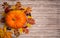 Pumpkin, colored leaves, hawthorn berries and Rowan on a wooden background.