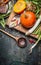 Pumpkin , cooking spoon and vegetables ingredients on dark rustic background, top view