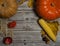 Pumpkin, corn cob, Apple, pumpkin seeds, Rowan berries and barley ears, walnuts and chestnuts, autumn leaves on a wooden backgrou