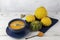 Pumpkin cream soup in a blue plate on a white boardwalk with small decorative pumpkins using dark blue textile and spoons