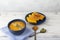 Pumpkin cream soup in a blue plate on a white wooden background using light blue textile and spoons. copy space