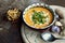 Pumpkin cream soup with ginger, garlic and spoon on grange background