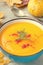 Pumpkin cream soup with rosemary and paprika in blue bowl. Halloween Thanksgiving Autumn food concept