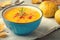 Pumpkin cream soup with rosemary and paprika in blue bowl. Halloween Thanksgiving Autumn food concept