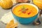 Pumpkin cream soup with rosemary and paprika in blue bowl. Halloween Thanksgiving Autumn food concept