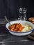 Pumpkin curry and cous cous on a dark wooden background.