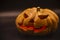 Pumpkin that is cut into a ghost face for Halloween, placed in a scary atmosphere, with candles shining in the dark. For use on Ha