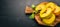 Pumpkin cut with slices on a wooden board. Fresh vegetables. On a black background. Free space for text.