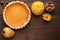 Pumpkin homemade pie at wooden background decorated with nuts, p