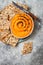 Pumpkin hummus seasoned with olive oil and black sesame seeds with whole grain crackers. Healthy vegetarian appetizer or snack.
