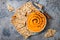 Pumpkin hummus seasoned with olive oil and black sesame seeds with whole grain crackers. Healthy vegetarian appetizer or snack.