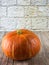 Pumpkin isolated on wooden ground in front of a wall of sandstone