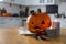 Pumpkin jack o`lantern, candles and Halloween decor on wooden table in kitchen, space for text