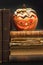 Pumpkin lantern for Halloween and the old witch books. Head carved from a pumpkin on Halloween. Pumpkin tradition.