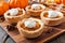 Pumpkin pie tarts, close up scene on a wooden server