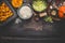 Pumpkin risotto cooking ingredients on dark rustic kitchen table with bowls, spoon and pan, top view, border. Vegetarian food