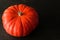 Pumpkin rouge vif d`Etampes isolated on a dark background with copy space.