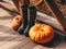 Pumpkin and rubber rain boots on a wooden floor