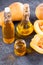 Pumpkin seed oil in a glass jar and fresh raw pampkin on a dark background. Healthy eating