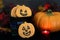 Pumpkin shaped cookies in a Halloween bucket in a fall setting, low light image with lit candle