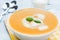 Pumpkin soup with basil and cream in white bowl. American traditional cuisine