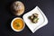 Pumpkin soup in a bowl with bread and roasted figs with goat cheese
