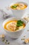 Pumpkin soup with cream, croutons, pumpkin seeds and parsley on a gray concrete or stone background.